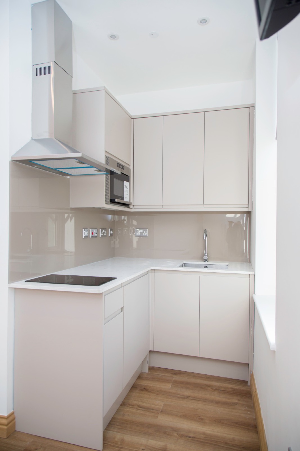 Finished cream gloss kitchen with a wood floor